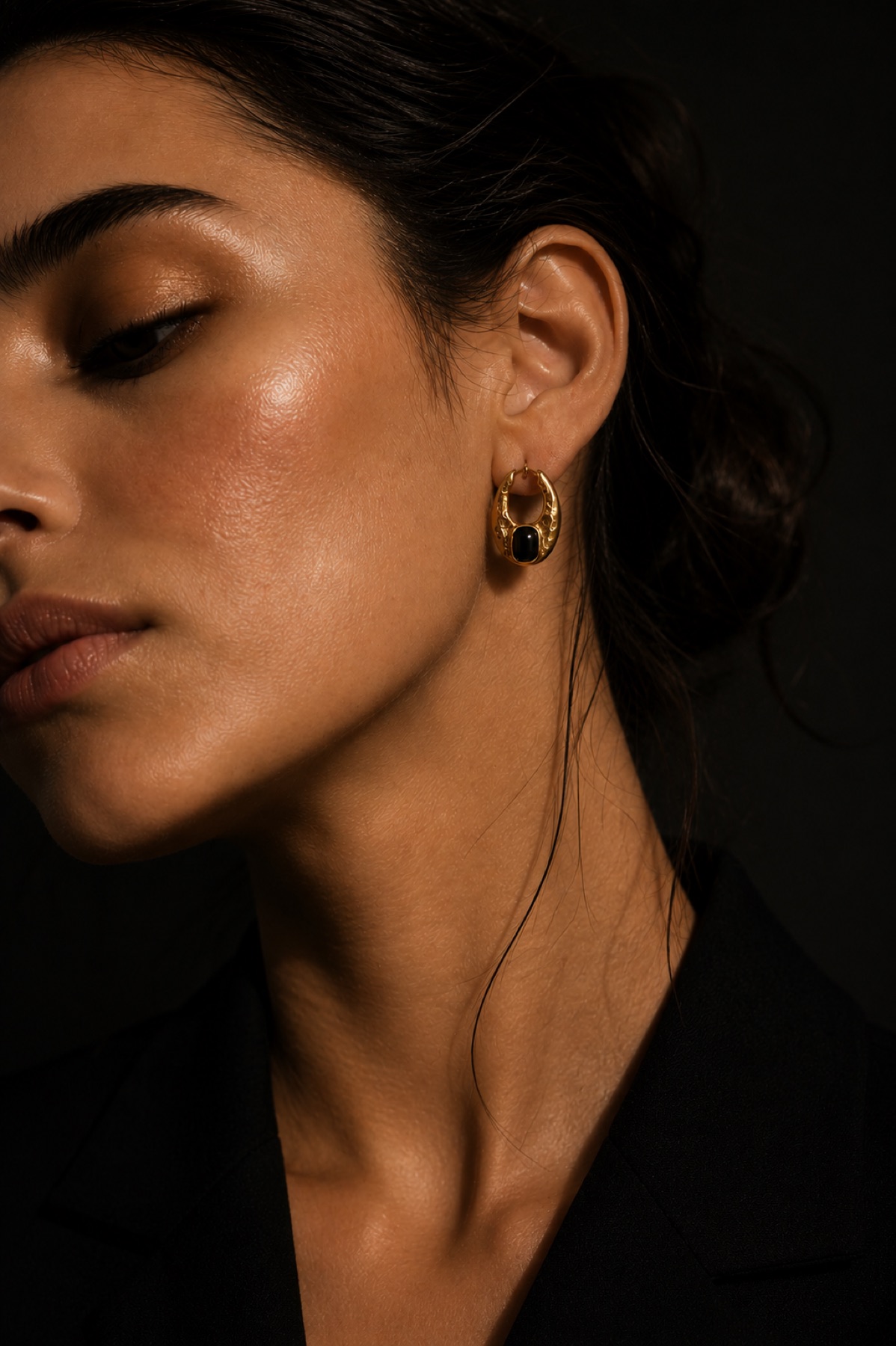 Eclipse artisan earrings worn in a dark editorial portrait